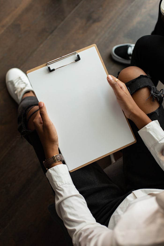 Top view of a person holding a blank clipboard, perfect for mockup designs.